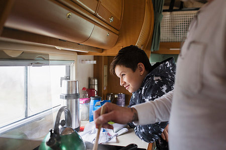 Father and soon cooking and looking out window in motor home Stock Photo - Premium Royalty-Free, Code: 6124-09188838