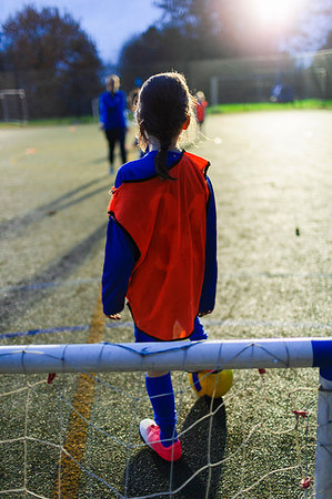 Girl playing soccer on field at night Stock Photo - Premium Royalty-Free, Code: 6124-09197406