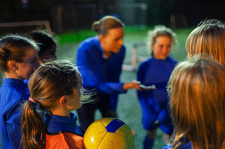 simsearch:400-06875366,k - Girl soccer players listening to coach in huddle Photographie de stock - Premium Libres de Droits, Code: 6124-09197420