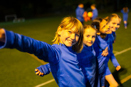 simsearch:700-00550133,k - Portrait smiling, confident girls soccer team on field at night Fotografie stock - Premium Royalty-Free, Codice: 6124-09197429