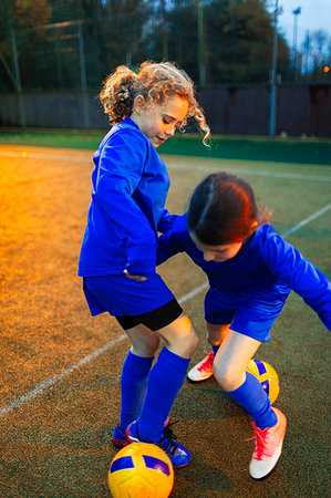 Girl soccer players practicing on field Photographie de stock - Premium Libres de Droits, Code: 6124-09197432