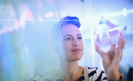 Innovative female entrepreneur examining glass cube prototype Photographie de stock - Premium Libres de Droits, Code: 6124-09130965