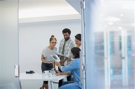 Creative business people discussing paperwork in conference room meeting Stock Photo - Premium Royalty-Free, Code: 6124-09131058