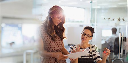 Creative businesswomen planning, discussing paperwork in office Foto de stock - Sin royalties Premium, Código: 6124-09131093