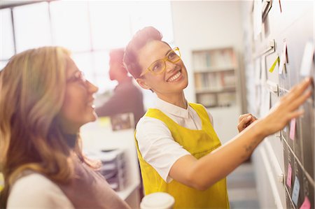 Smiling, confident creative businesswomen planning, brainstorming at blackboard Foto de stock - Sin royalties Premium, Código: 6124-09131022