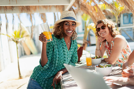 pictures of women drinking juice on a beach - Portrait happy woman drinking cocktail at sunny beach bar Stock Photo - Premium Royalty-Free, Code: 6124-09269604