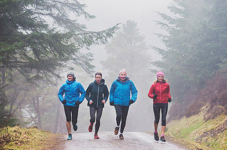 dad daughter rain - Family jogging in woods Stock Photo - Premium Royalty-Free, Code: 6124-09269620