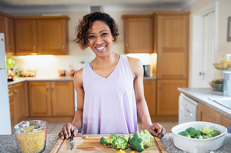 simsearch:6113-08393754,k - Portrait smiling, confident woman cooking in kitchen Stock Photo - Premium Royalty-Free, Code: 6124-09269959