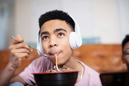 dinner live music - Teenage boy with headphones eating noodles Stock Photo - Premium Royalty-Free, Code: 6124-09269996