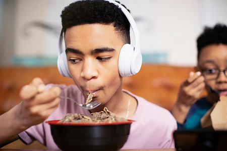 dinner live music - Teenage boy with headphones eating Stock Photo - Premium Royalty-Free, Code: 6124-09269934