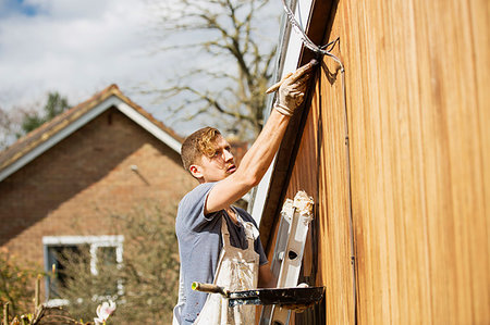 simsearch:400-06741696,k - Male painter on ladder painting home exterior trim Photographie de stock - Premium Libres de Droits, Code: 6124-09270018