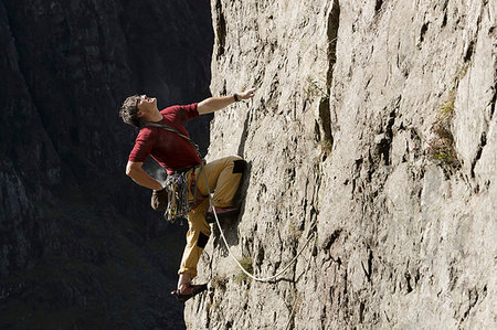 simsearch:841-09255762,k - Male rock climber scaling rock face, looking up Stockbilder - Premium RF Lizenzfrei, Bildnummer: 6124-09270030