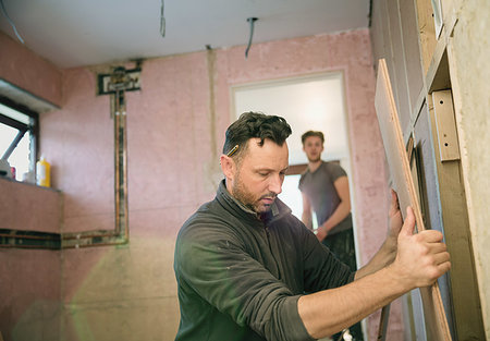 Construction worker holding wood board, framing house Stock Photo - Premium Royalty-Free, Code: 6124-09229056