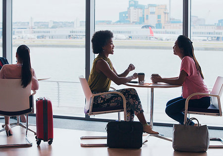 Businesswomen talking and drinking coffee in airport business lounge Photographie de stock - Premium Libres de Droits, Code: 6124-09229178
