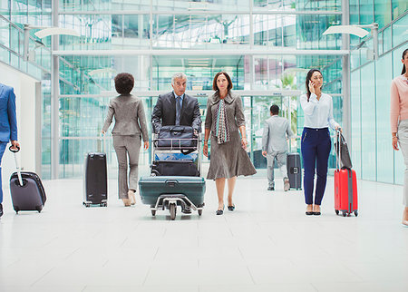 simsearch:6118-08394232,k - Business people walking with luggage in airport Photographie de stock - Premium Libres de Droits, Code: 6124-09229126