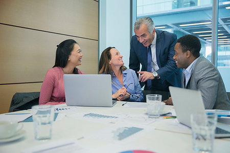 simsearch:6124-09269855,k - Smiling business people using laptop in conference room meeting Stock Photo - Premium Royalty-Free, Code: 6124-09229204