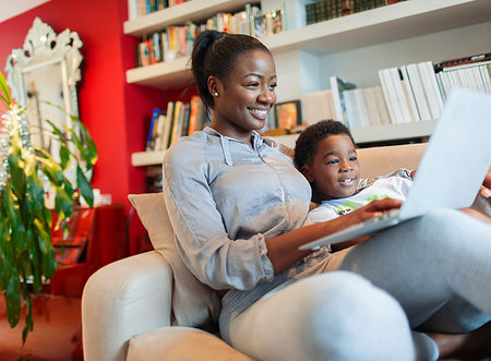 simsearch:6113-08910061,k - Mother and son  using laptop on living room sofa Photographie de stock - Premium Libres de Droits, Code: 6124-09239208