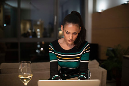 simsearch:6115-08104883,k - Focused woman drinking white wine and working at laptop at home at night Photographie de stock - Premium Libres de Droits, Code: 6124-09239383