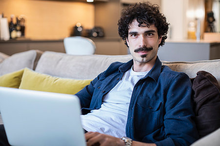 simsearch:400-04443819,k - Portrait confident man using laptop on living room sofa Stock Photo - Premium Royalty-Free, Code: 6124-09239384