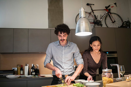 simsearch:6113-06720670,k - Couple cutting vegetables, cooking dinner in apartment kitchen Foto de stock - Sin royalties Premium, Código: 6124-09239442