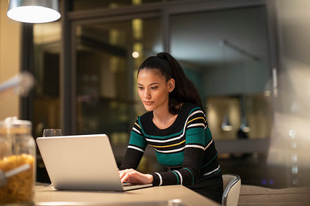 simsearch:630-06723796,k - Focused woman using laptop at home at night Stock Photo - Premium Royalty-Free, Code: 6124-09239453