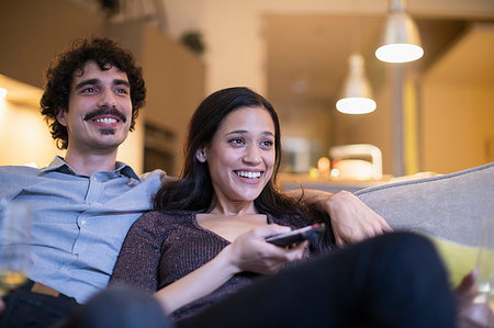 simsearch:6108-06166991,k - Happy couple watching TV on sofa Stock Photo - Premium Royalty-Free, Code: 6124-09239411