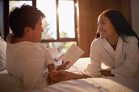 simsearch:6113-08171391,k - Couple in bathrobes reading book in bed Foto de stock - Royalty Free Premium, Número: 6124-09239595