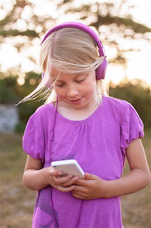 Sweden, Gotland, Faro, Girl (8-9) listening to music from smart phone Stock Photo - Premium Royalty-Free, Code: 6126-08642793