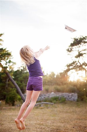 paper plane kid - Sweden, Gotland, Faro, Girl (8-9) throwing paper airplane into air Stock Photo - Premium Royalty-Free, Code: 6126-08642794