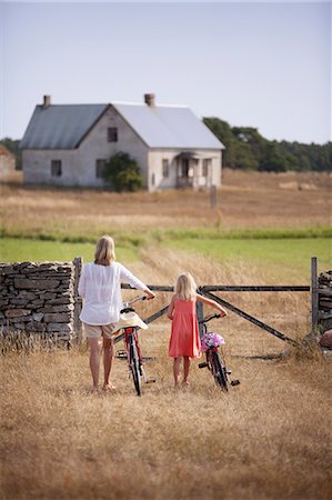 swedish - Sweden, Gotland, Faro, Mother and daughter (8-9) wheeling bicycles toward farm gate Stock Photo - Premium Royalty-Free, Code: 6126-08642799