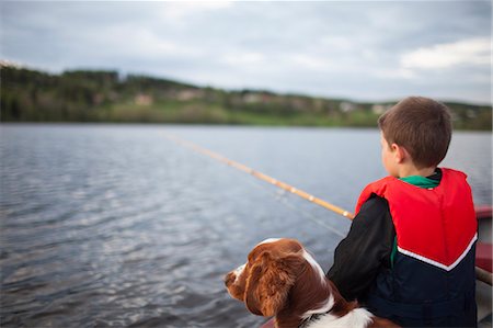 Sweden, Medelpad, Boy (8-9) fishing with dog Stock Photo - Premium Royalty-Free, Code: 6126-08642958