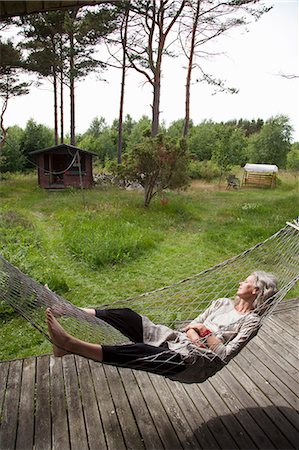Sweden, Bohuslan, Woman relaxing in hammock Stock Photo - Premium Royalty-Free, Code: 6126-08642932