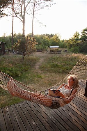 scandinavian woman 50 years old - Sweden, Bohuslan, Woman reading book in hammock Stock Photo - Premium Royalty-Free, Code: 6126-08642937