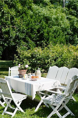 simsearch:6126-08643764,k - Sweden, Gotland, Bursvik, Burgegard, White table and chairs in garden Stock Photo - Premium Royalty-Free, Code: 6126-08643049