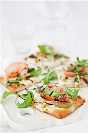 simsearch:6126-08643018,k - Sweden, Pizza with goat cheese cream, rocket, pine nuts, figs and parma ham Photographie de stock - Premium Libres de Droits, Code: 6126-08643007