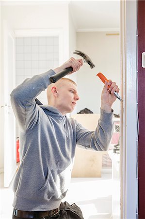 Sweden, Young man renovating house Photographie de stock - Premium Libres de Droits, Code: 6126-08643010