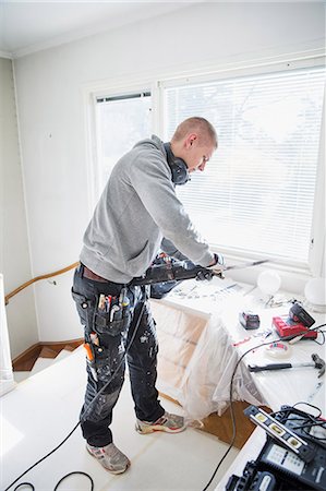 simsearch:6126-08644046,k - Sweden, Young man adjusting drill Stock Photo - Premium Royalty-Free, Code: 6126-08643012