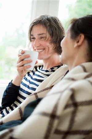 simsearch:6126-08644371,k - Two women having coffee in living room Photographie de stock - Premium Libres de Droits, Code: 6126-08643241