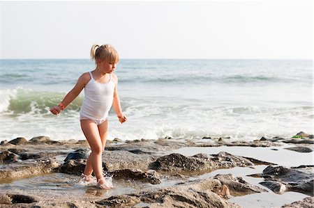 simsearch:6126-08643277,k - Turkey, Alanya, Blonde girl (4-5) walking on rock beach Foto de stock - Royalty Free Premium, Número: 6126-08643273