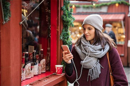 Sweden, Stockholm, Gamla Stan, Woman using phone at market Photographie de stock - Premium Libres de Droits, Code: 6126-08643210