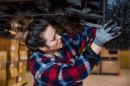 female mechanic clothing - Sweden, Female mechanic adjusting wheel Stock Photo - Premium Royalty-Free, Code: 6126-08643225