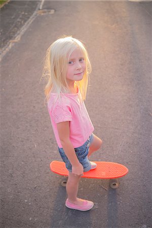 simsearch:6126-09103095,k - Sweden, Smaland, Anderstorp, Portrait of girl (8-9) riding red shortboard in street Foto de stock - Sin royalties Premium, Código: 6126-08643845