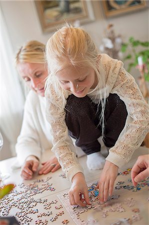 simsearch:6126-08643852,k - Sweden, Girl (8-9) making jigsaw puzzle Stock Photo - Premium Royalty-Free, Code: 6126-08643849