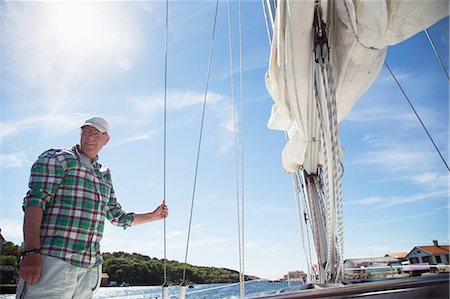 simsearch:6102-08120162,k - Sweden, West Coast, Bohuslan, Marstrand, Mature man standing on deck of sailboat Photographie de stock - Premium Libres de Droits, Code: 6126-08643884