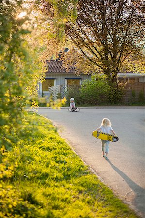 simsearch:6126-08636115,k - Sweden, Vastergotland, Lerum, Girl (6-7) walking to boy (8-9) with skateboard Photographie de stock - Premium Libres de Droits, Code: 6126-08643822