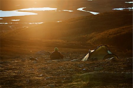Sweden, Vasterbotten, Hemavan, Man camping at sunset Foto de stock - Sin royalties Premium, Código: 6126-08643932