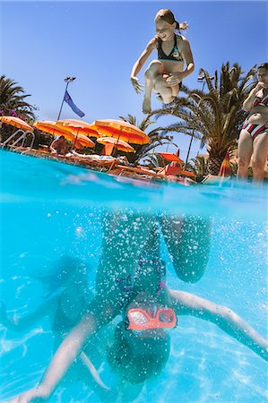 parasol de plage - Italy, Sardinia, Alghero, Mother watching children (14-15, 16-17) diving into swimming pool Photographie de stock - Premium Libres de Droits, Code: 6126-08644087