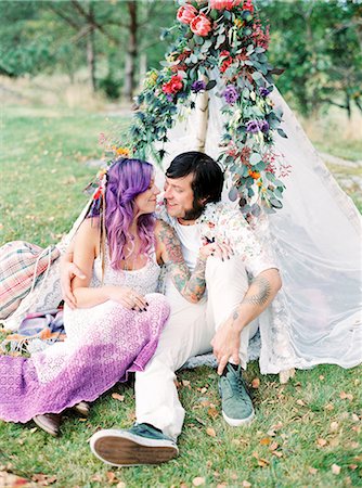 Sweden, Bride and groom sitting on grass by white tent at hippie wedding Foto de stock - Sin royalties Premium, Código: 6126-08644286
