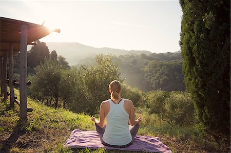 simsearch:6126-08644371,k - Italy, Tuscany, Dicomano, Woman in lotus position facing green hills Photographie de stock - Premium Libres de Droits, Code: 6126-08644367