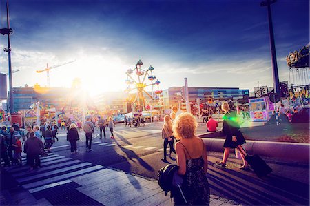 simsearch:6102-08480904,k - Sweden, Skane, Malmo, Anna Lindhs Plats, Woman crossing city street towards travelling carnival ground Stock Photo - Premium Royalty-Free, Code: 6126-08644499